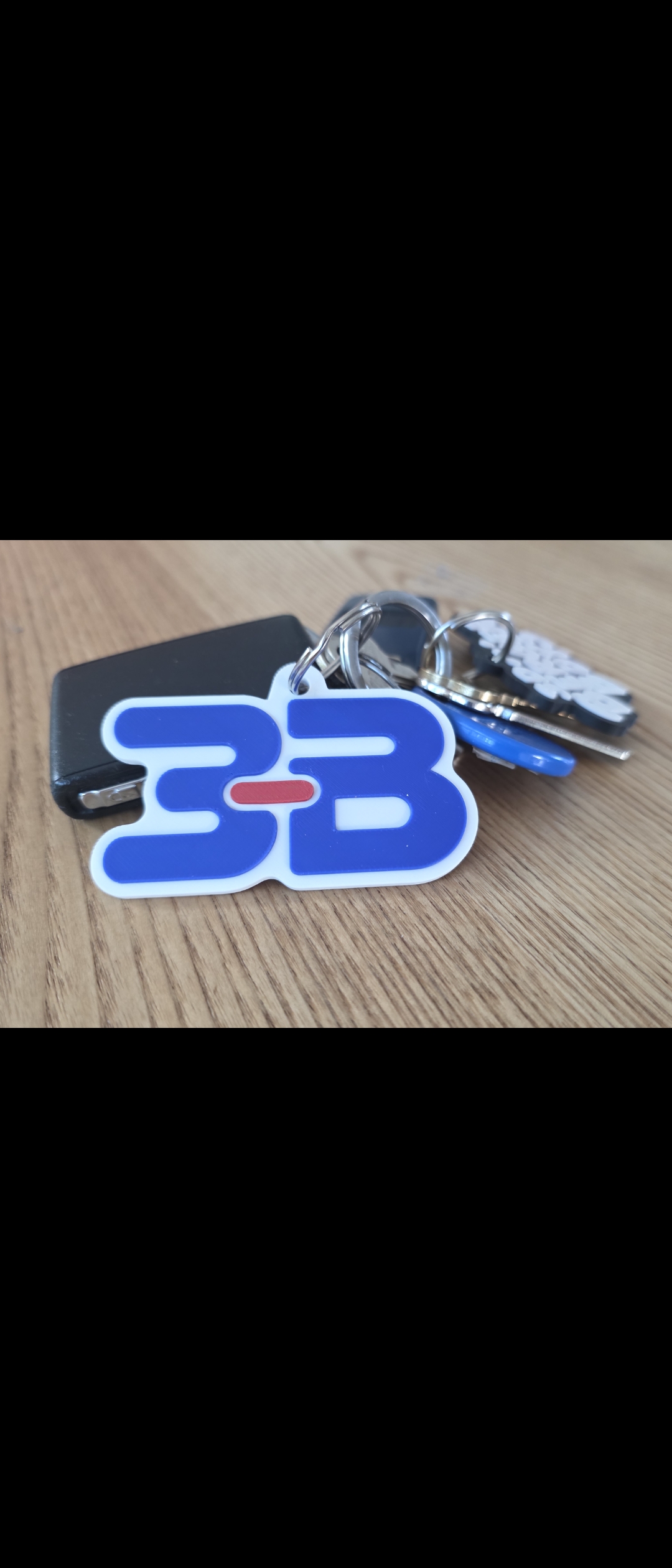 Close-up of our blue, white and red 3B keyring on a set of keys.